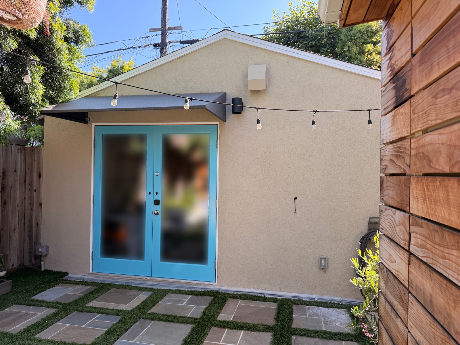 The converted garage workspace at the back of the lot, with turquoise French doors